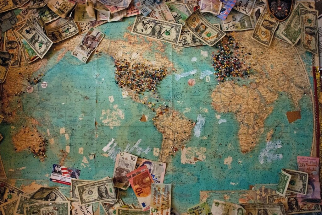 Mapa viejo con marcadores y monedas de todo el mundo.