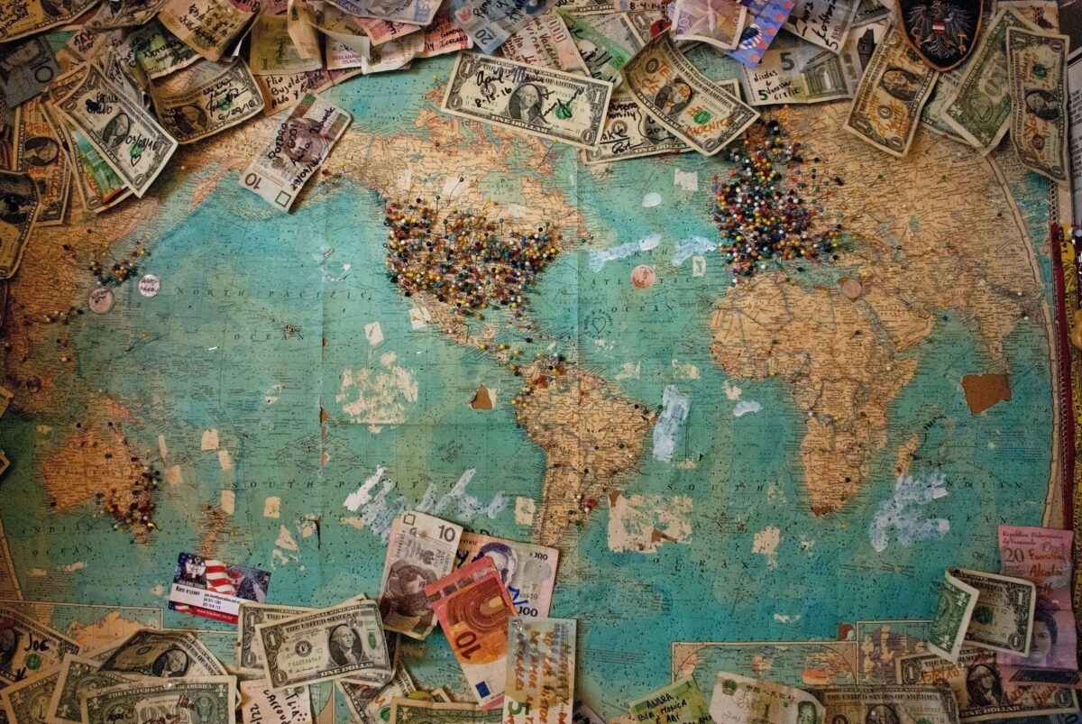 Mapa viejo con marcadores y monedas de todo el mundo.